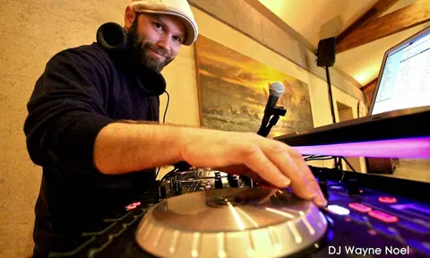DJ Wayne Noel smiling at the decks at Ramekins in Sonoma