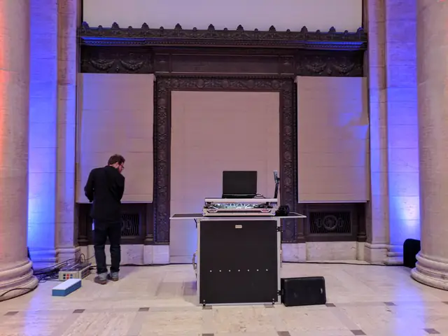 DJ booth with controller and laptop set up between stone columns under an ornate bronze doorway at the Asian Art Museum in San Francisco