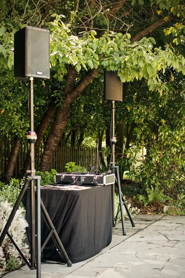 DJ speakers and a draped table set up on the flagstone patio beside the Brazilian Room at Tilden Park, Berkeley