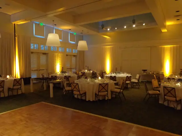Event room at Carneros Resort and Spa with a parquet dance floor, candlelit round tables and amber uplighting on the walls