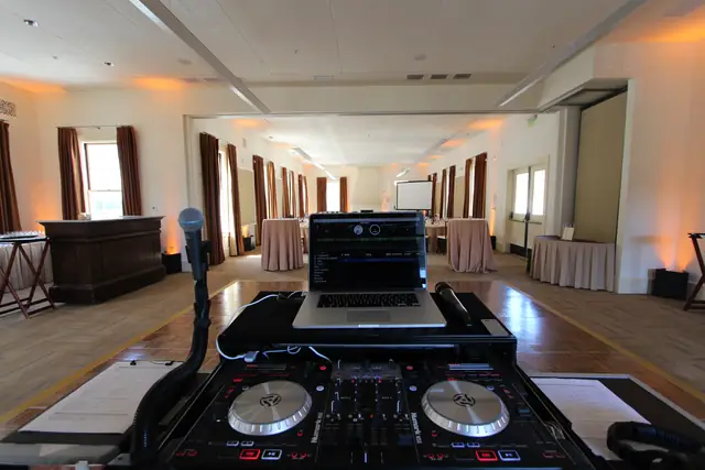 DJ Wayne Noel's controller and laptop set up facing the dance floor in the cream reception room at Cavallo Point