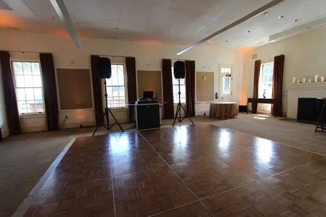 DJ booth with two speakers on stands beside the parquet dance floor in the cream room at Cavallo Point