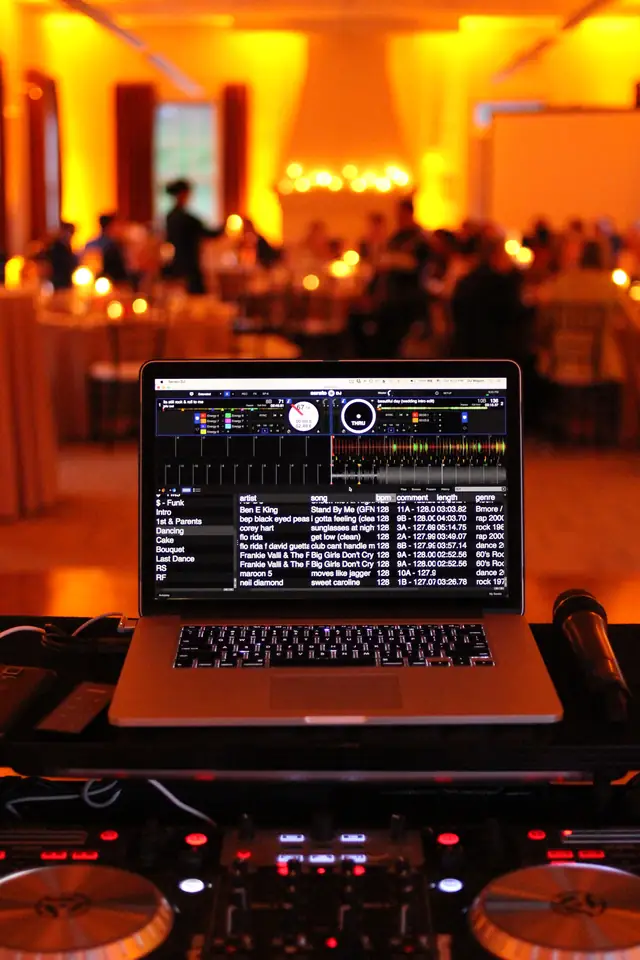 DJ Wayne Noel's laptop and controller with the candlelit amber reception room behind at Cavallo Point