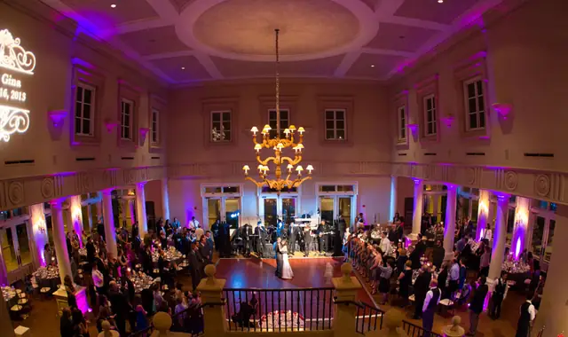 First dance on the ballroom floor at The Club at Ruby Hill under purple uplighting, seen from the balcony