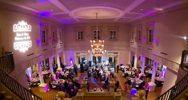 Ballroom at The Club at Ruby Hill from the balcony with lavender uplighting and a monogram projected on the wall