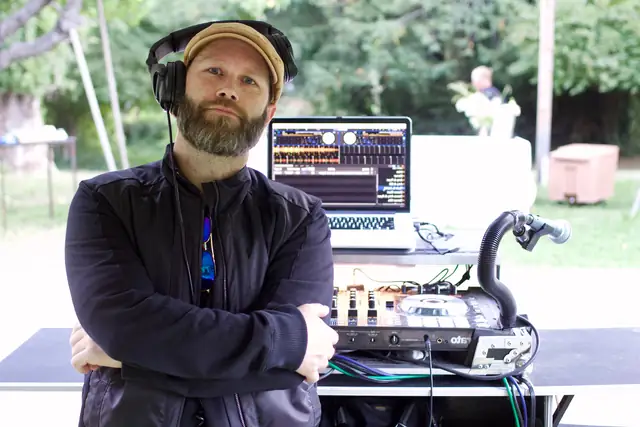 DJ Wayne Noel in headphones behind his controller and laptop at an outdoor Dawn Ranch event