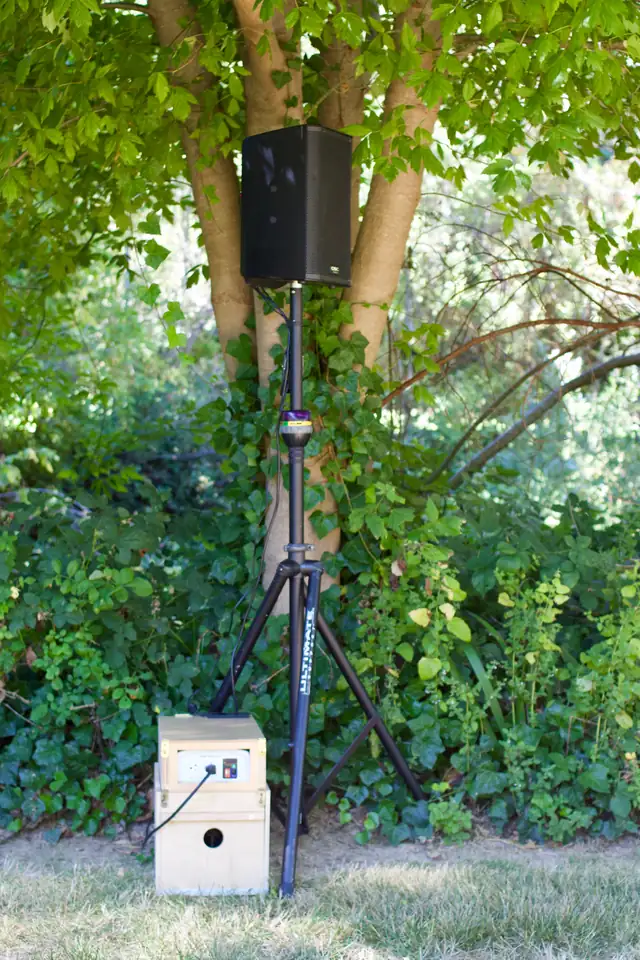 Speaker on a stand and a power box set up under a tree at Dawn Ranch for an outdoor event