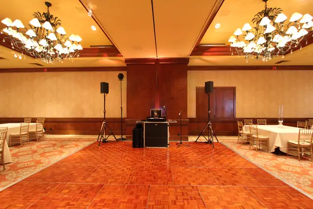 Wayne Noel's DJ setup with speakers and booth on the parquet dance floor in the ballroom at the Inn at Spanish Bay