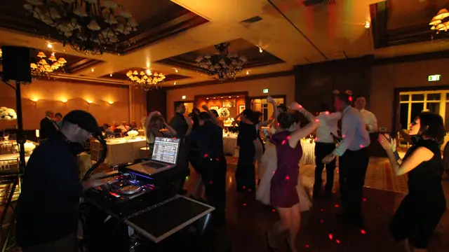 Wayne Noel working the DJ controller while couples dance at the Inn at Spanish Bay ballroom