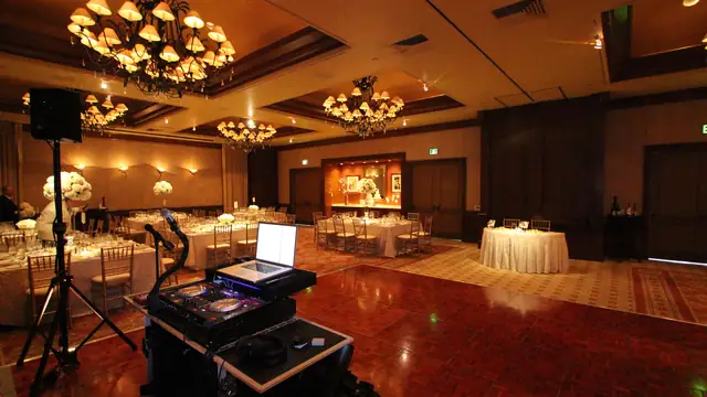 View from the DJ booth across the dance floor to dressed banquet tables at the Inn at Spanish Bay ballroom