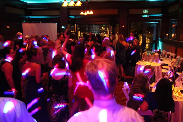 Full dance floor under pink and blue dance lighting and teal uplighting at Inn Marin