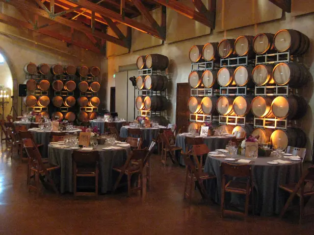 Round dinner tables set in front of stacked wine barrels at Jacuzzi Family Vineyards in Sonoma