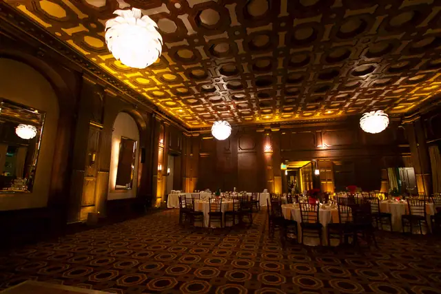 Angled view of the Julia Morgan Ballroom in San Francisco with pendant lights, mirrored alcoves and set tables