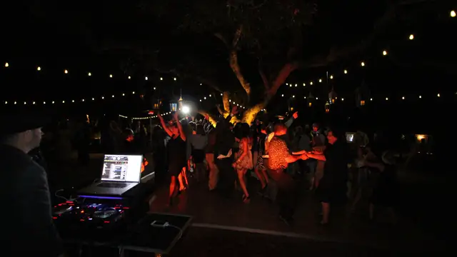 Guests dancing under string lights and lanterns in the oak grove at Kunde Family Winery while DJ Wayne Noel plays