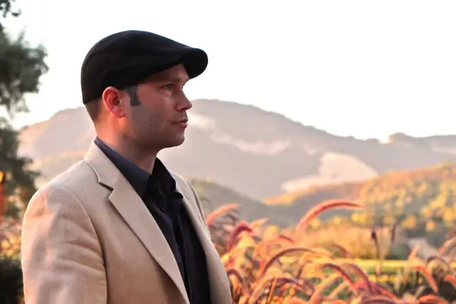 DJ Wayne Noel in profile at golden hour with the hills around Kunde Family Winery behind him