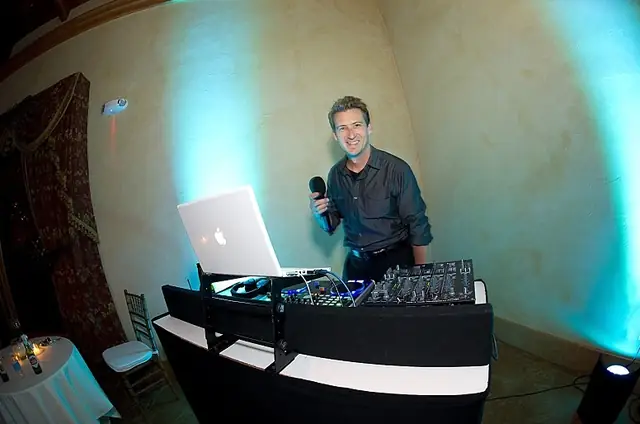 DJ Wayne Noel at his booth with a microphone in the Stone Room at The Lodge at Sonoma, Sonoma