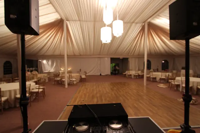Wayne Noel's DJ controller and speakers facing the empty dance floor in the draped tent at The Lodge at Sonoma