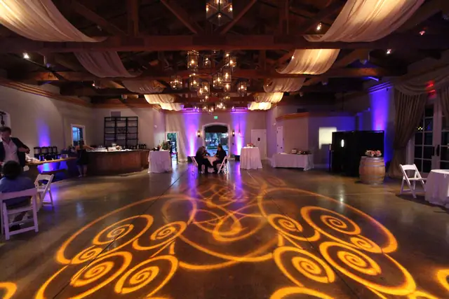 The Lodge at Sonoma Stone Room looking toward the entry, with bar, wine barrel and amber pattern lighting on the floor