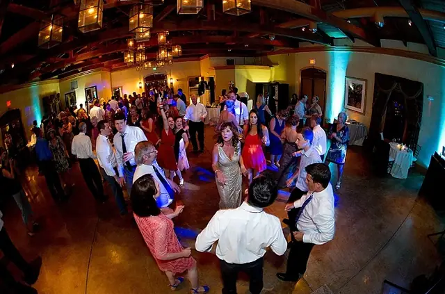 Wedding guests filling the dance floor under the lantern chandeliers in the Stone Room at The Lodge at Sonoma, Sonoma