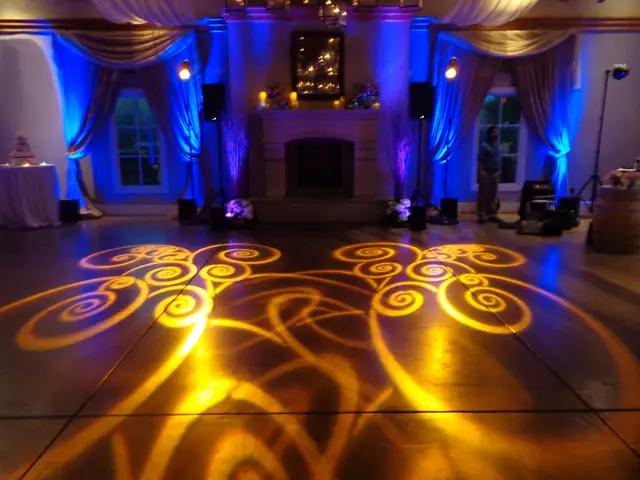 Amber swirl pattern lighting on the polished floor of the Stone Room at The Lodge at Sonoma, with blue uplit curtains and a fireplace