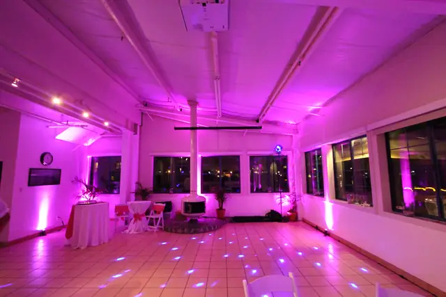 Mavericks House room with pink uplighting and a white hanging fireplace at the far wall