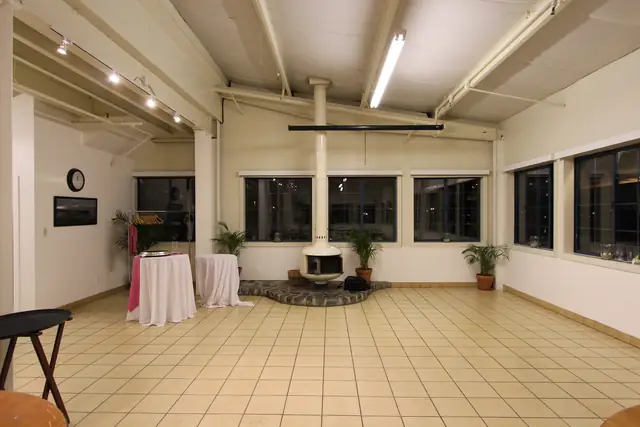 Open tile floor and round white hanging fireplace in the room at Mavericks House by daylight