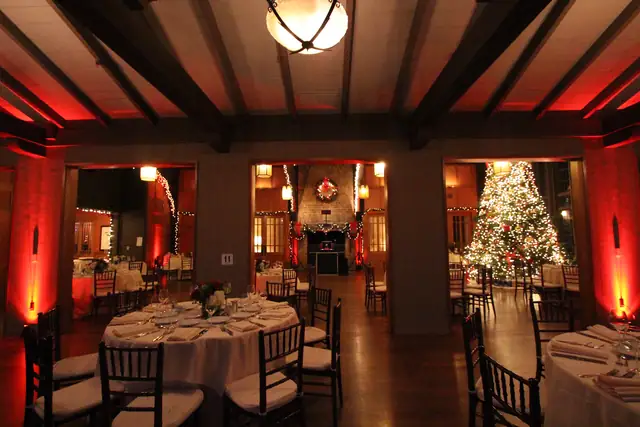 Doorways between rooms at the Meadow Club with beamed ceiling and red uplighting, DJ booth visible in the central doorway