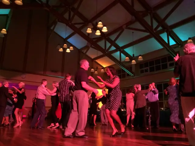 Couples partner dancing on a full dance floor under the timber trusses at Mill Valley Community Center in Mill Valley