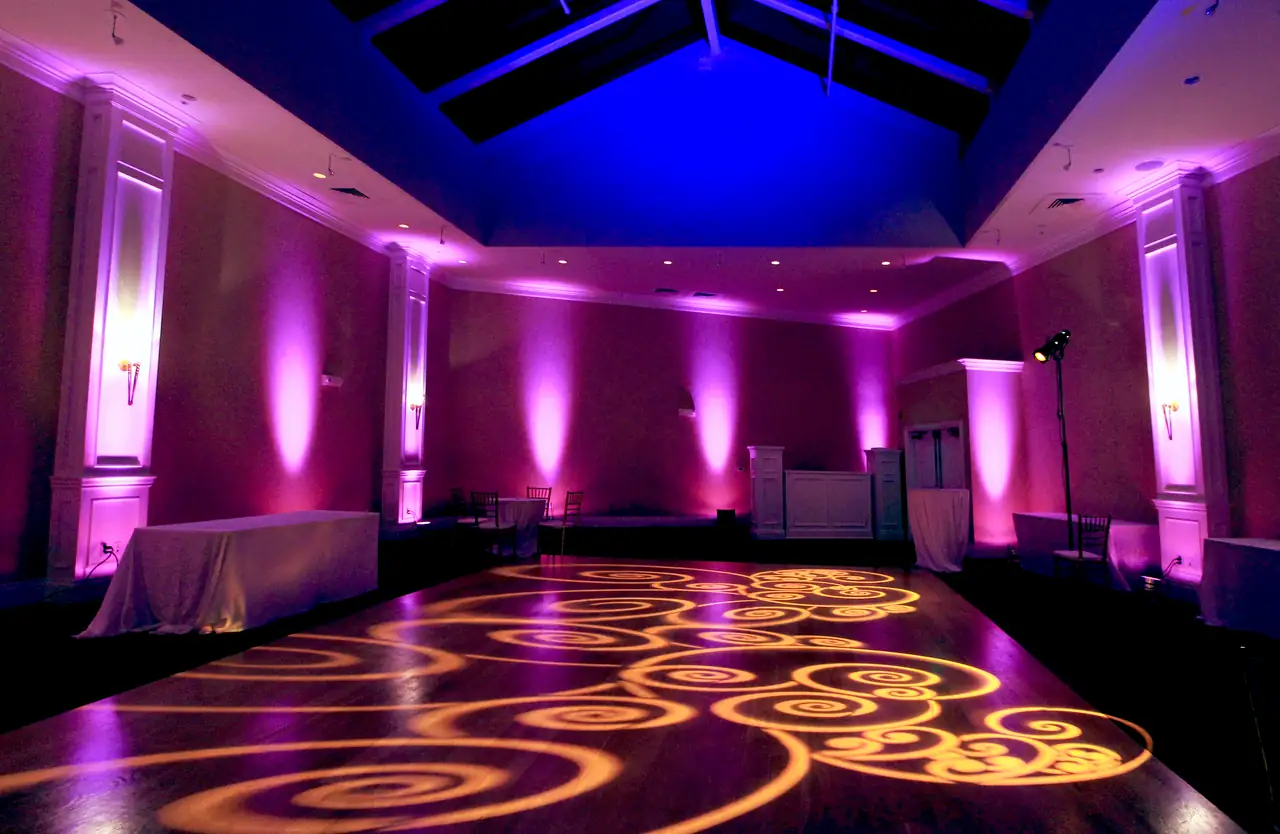 Atrium at Oceano Hotel and Spa in Half Moon Bay with magenta uplighting, a blue skylight wash and amber swirl pattern lighting across the dance floor