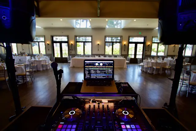 DJ controller and laptop set up between speakers in the garden-window event room at Oceano Hotel and Spa