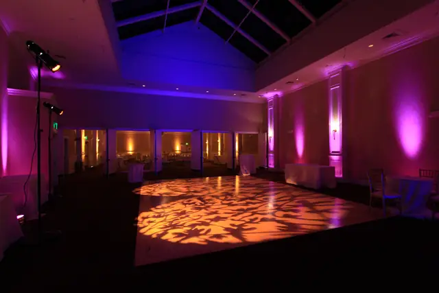 Oceano Hotel and Spa ballroom dance floor with amber leaf-pattern lighting, two lighting stands and magenta wall uplights