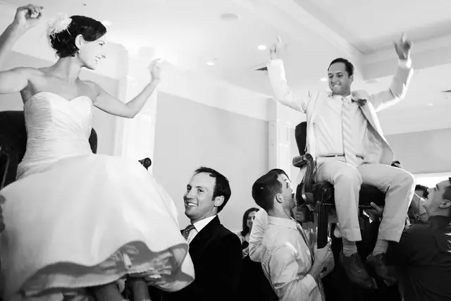 A bride and groom lifted on chairs during the hora in the ballroom at Oceano Hotel and Spa, Half Moon Bay
