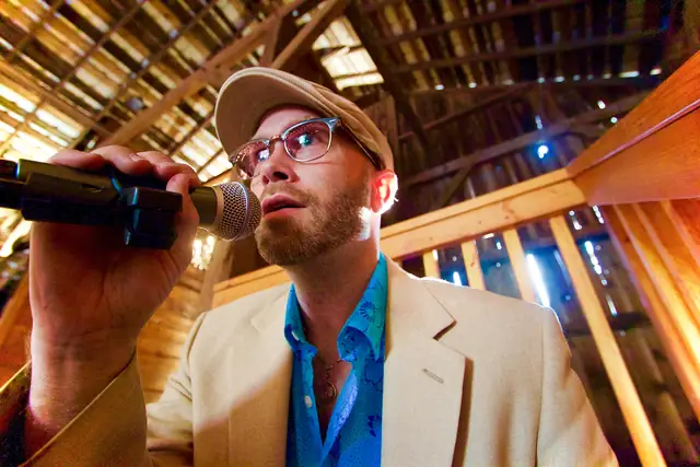 Wayne Noel speaking into a microphone inside the barn at Olympia's Valley Estate