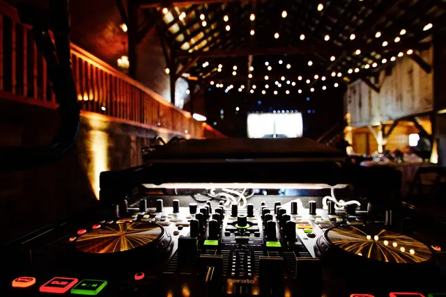 View from behind Wayne's DJ controller looking across the barn at Olympia's Valley Estate, string lights overhead