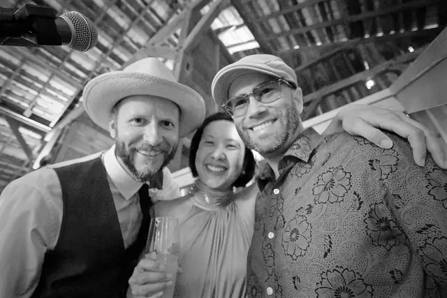 DJ Wayne Noel smiling with two wedding clients under the barn rafters at Olympia's Valley in Petaluma