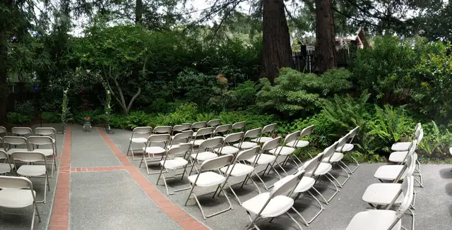 Outdoor ceremony space at the Mill Valley Outdoor Art Club with white chairs set among redwoods and ferns