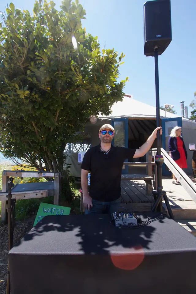 DJ Wayne Noel at his table with a speaker outside the yurt at Slide Ranch on a sunny day
