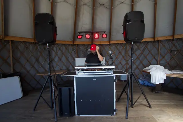 DJ booth, speakers, subwoofer and red lights set up inside the Slide Ranch yurt