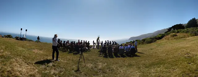 Panorama of an outdoor ceremony above the ocean at Slide Ranch with the DJ speakers at the edge