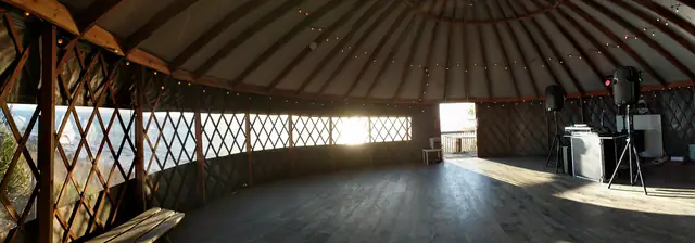 Sunlit panorama of the yurt at Slide Ranch with window views, wood floor and DJ setup