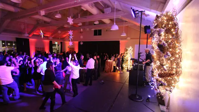 Guests dancing while DJ Wayne Noel plays from the stage at a holiday party at Solage, Calistoga