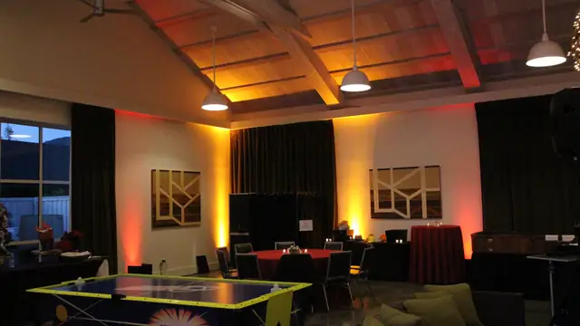 Amber and red uplighting on the walls and ceiling of the Solage event hall at dusk