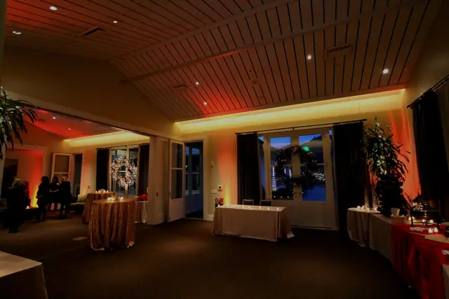 Reception room at Solage in Calistoga with red and amber uplighting and patio doors at dusk