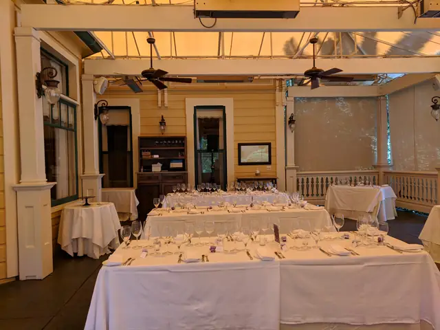 Covered porch at The Madrona with ceiling fans, set with long white-clothed tables for a dinner