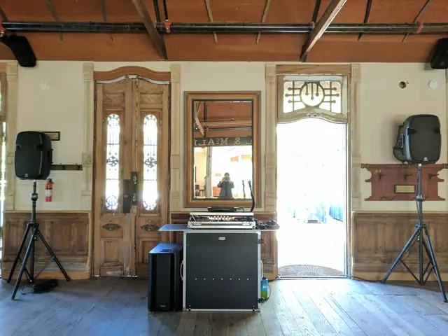DJ booth and two speakers set up in the historic wood-beamed barn at Triple S Ranch