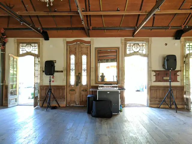 Full DJ setup on the plank floor of the historic barn at Triple S Ranch with open doors and stained-glass transoms