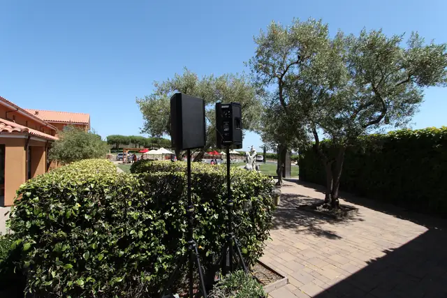 Speakers set up on the brick patio among olive trees and hedges at Viansa Winery