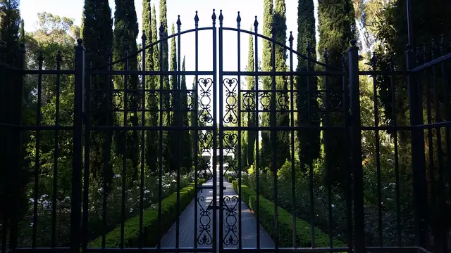 Wrought iron gate opening onto the rose garden path at Villa Montalvo